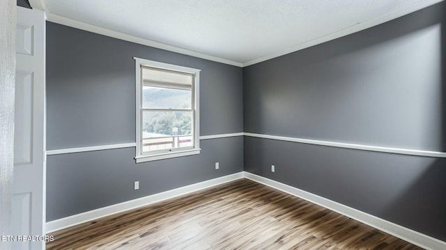 unfurnished room with hardwood / wood-style flooring and ornamental molding