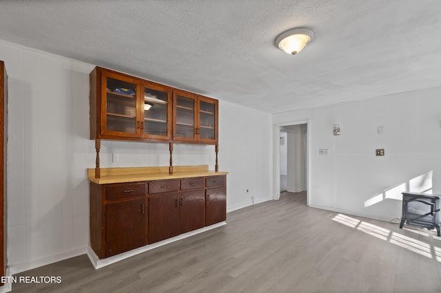 interior space featuring hardwood / wood-style flooring, a textured ceiling, and a wood stove