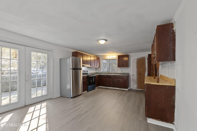 kitchen featuring french doors, appliances with stainless steel finishes, sink, and light hardwood / wood-style flooring