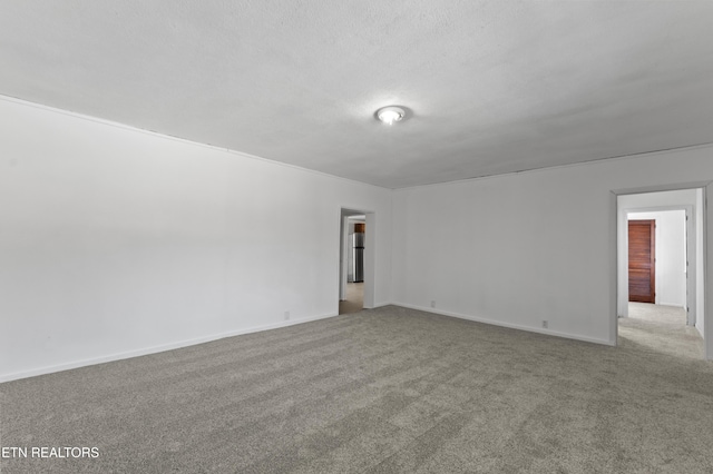 carpeted empty room featuring a textured ceiling