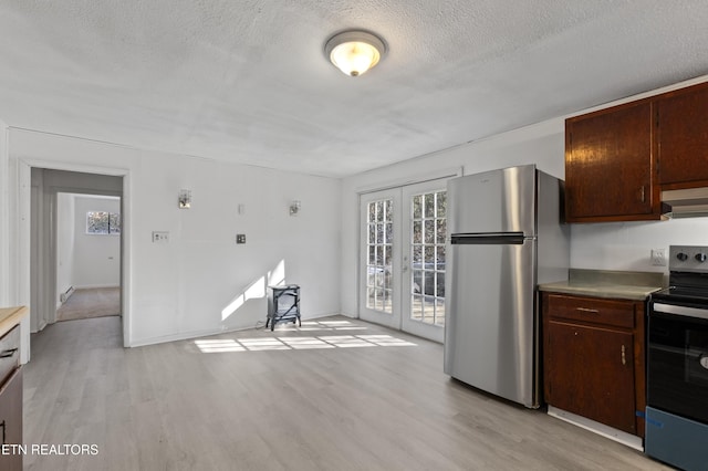 kitchen featuring appliances with stainless steel finishes, french doors, dark brown cabinetry, a textured ceiling, and light hardwood / wood-style flooring