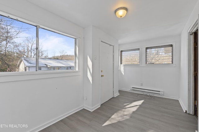 entrance foyer with a healthy amount of sunlight, hardwood / wood-style floors, and baseboard heating