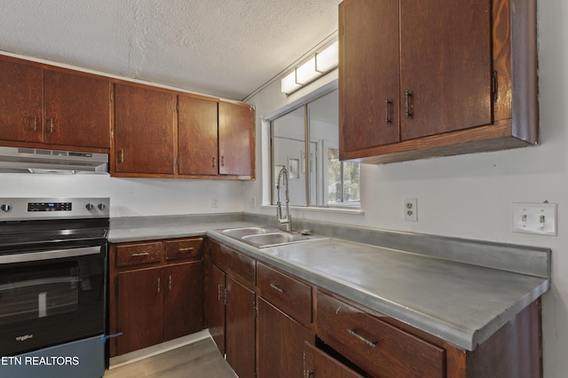 kitchen with sink, stainless steel range with electric cooktop, a textured ceiling, and light hardwood / wood-style flooring