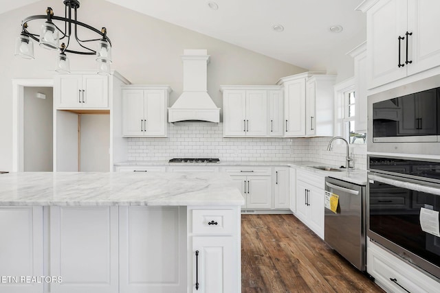 kitchen with premium range hood, stainless steel appliances, backsplash, white cabinets, and sink