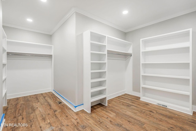 walk in closet with hardwood / wood-style floors