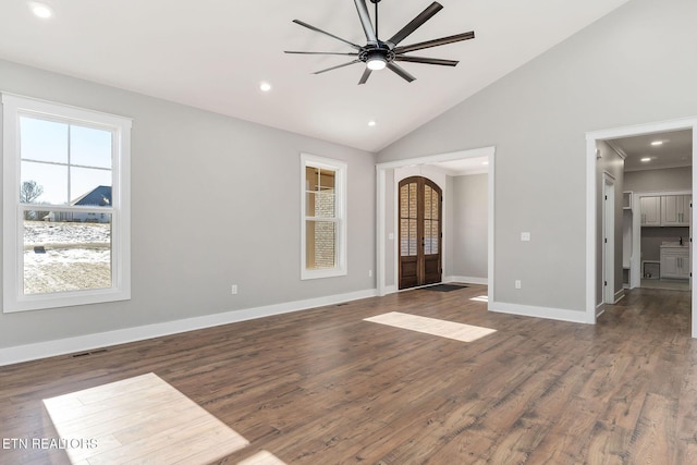 unfurnished room with ceiling fan, dark hardwood / wood-style flooring, french doors, and high vaulted ceiling