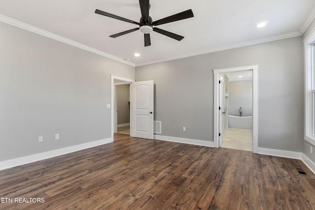 unfurnished bedroom with ceiling fan, dark wood-type flooring, ensuite bath, and crown molding