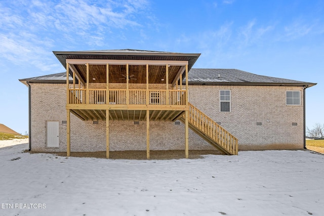 snow covered rear of property featuring a deck