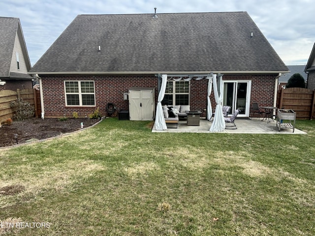 back of property featuring brick siding, a yard, a patio area, a fenced backyard, and an outdoor living space