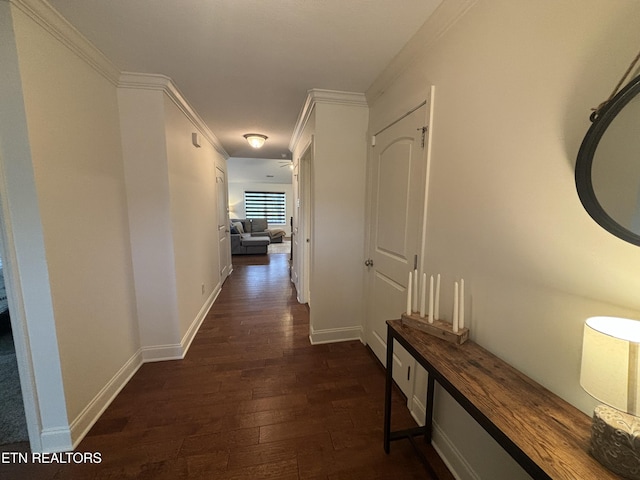 hallway with baseboards, ornamental molding, and dark wood-type flooring