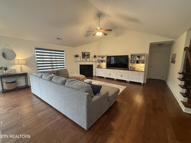 living room featuring ceiling fan, dark hardwood / wood-style floors, and lofted ceiling