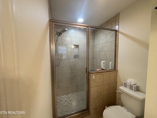 bathroom with an enclosed shower and toilet