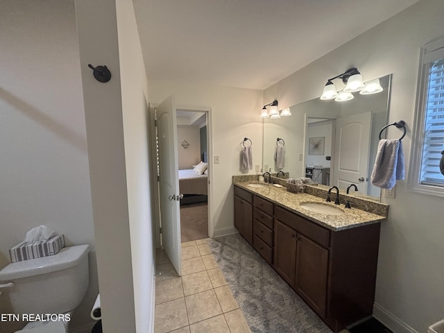 ensuite bathroom featuring double vanity, ensuite bath, a sink, and toilet