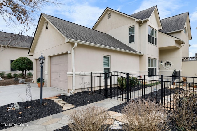 view of property exterior featuring a garage, roof with shingles, fence, and stucco siding