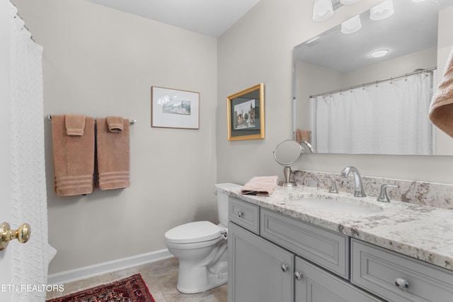 bathroom featuring tile patterned flooring, baseboards, vanity, and toilet