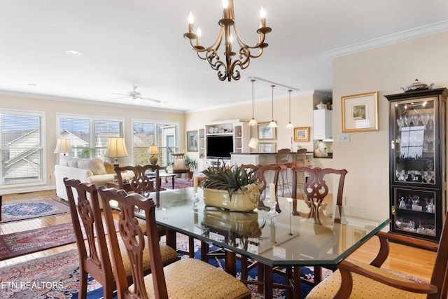 dining area with ceiling fan, baseboards, crown molding, and wood finished floors