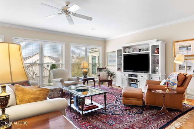 living area featuring ceiling fan, baseboards, crown molding, and wood finished floors