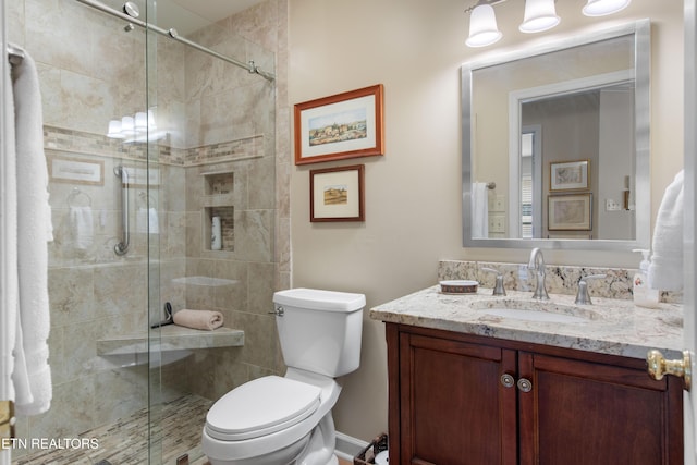 full bath featuring a stall shower, vanity, and toilet