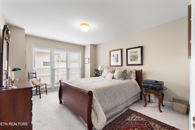 bedroom featuring light carpet and baseboards