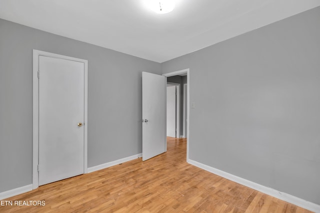 unfurnished bedroom with light hardwood / wood-style floors and a closet