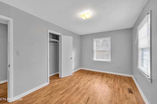 unfurnished bedroom with a closet and light hardwood / wood-style flooring