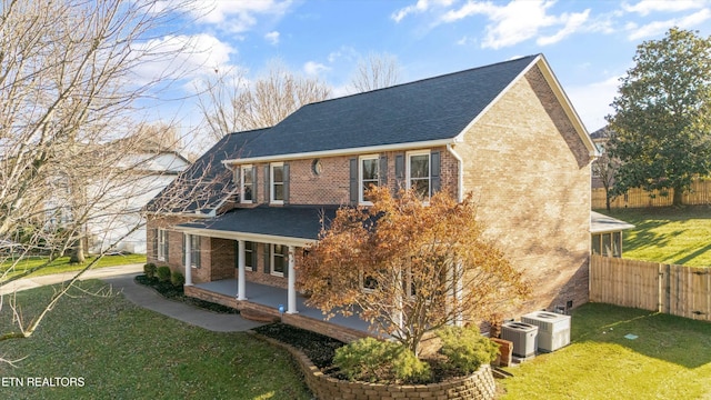 rear view of house featuring a yard and central air condition unit