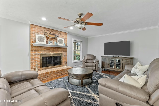 living room with crown molding, hardwood / wood-style floors, a textured ceiling, and a brick fireplace