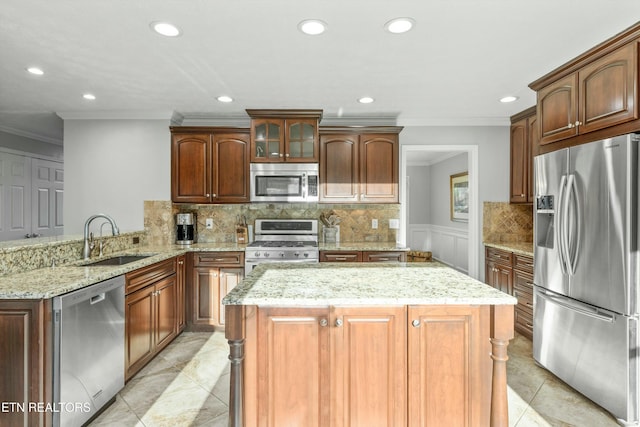 kitchen featuring sink, kitchen peninsula, stainless steel appliances, and ornamental molding