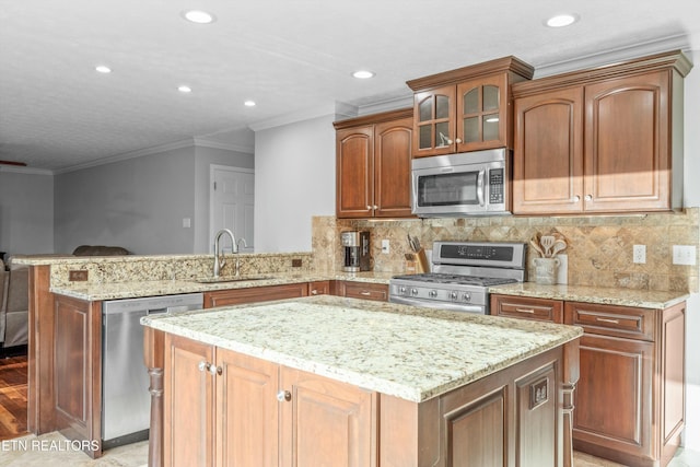 kitchen with sink, backsplash, kitchen peninsula, crown molding, and appliances with stainless steel finishes