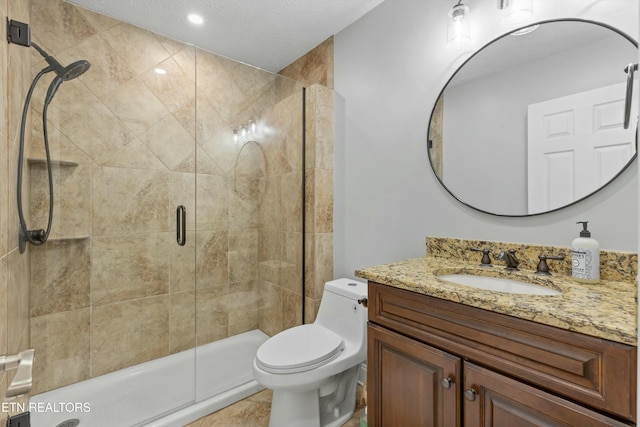 bathroom with tile patterned flooring, vanity, toilet, and walk in shower