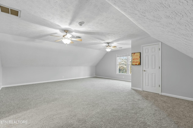 additional living space with carpet flooring, a textured ceiling, ceiling fan, and lofted ceiling