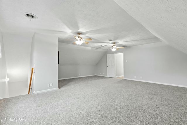 bonus room featuring carpet, a textured ceiling, vaulted ceiling, and ceiling fan