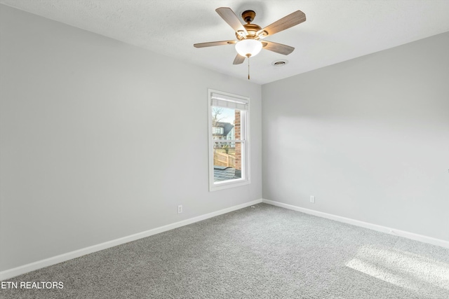 carpeted spare room featuring ceiling fan