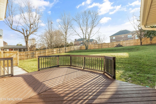 wooden deck featuring a lawn