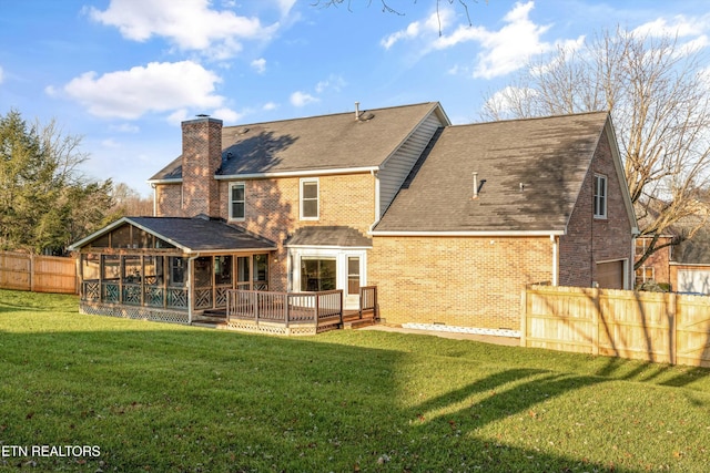 back of house with a deck and a yard