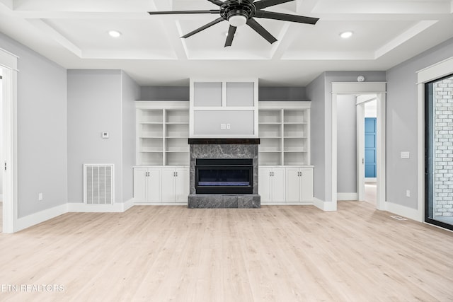 unfurnished living room with ceiling fan, light hardwood / wood-style floors, a high end fireplace, and coffered ceiling