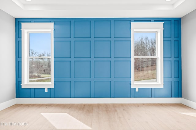 interior space featuring a tray ceiling and light hardwood / wood-style floors