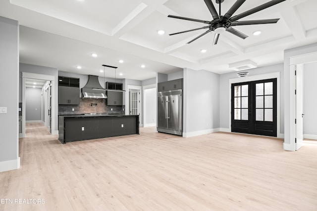 unfurnished living room with coffered ceiling, french doors, ceiling fan, beam ceiling, and light hardwood / wood-style floors