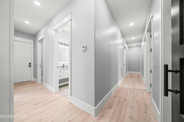 hall featuring light wood-type flooring and sink