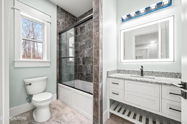 full bathroom with shower / bath combination with glass door, tile patterned flooring, vanity, and toilet