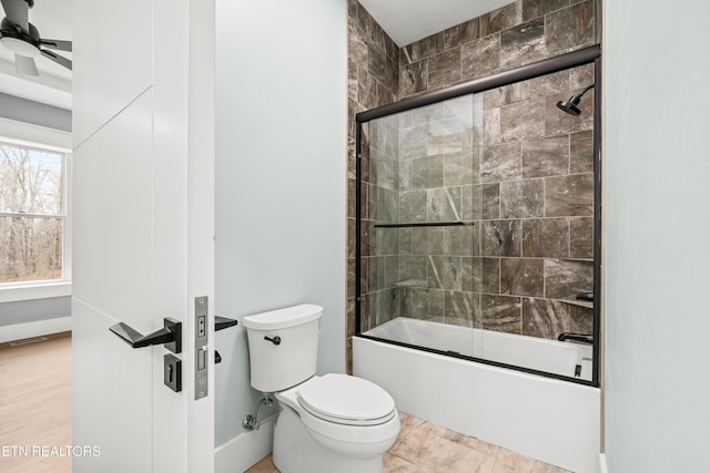 bathroom featuring tile patterned floors, toilet, ceiling fan, and combined bath / shower with glass door