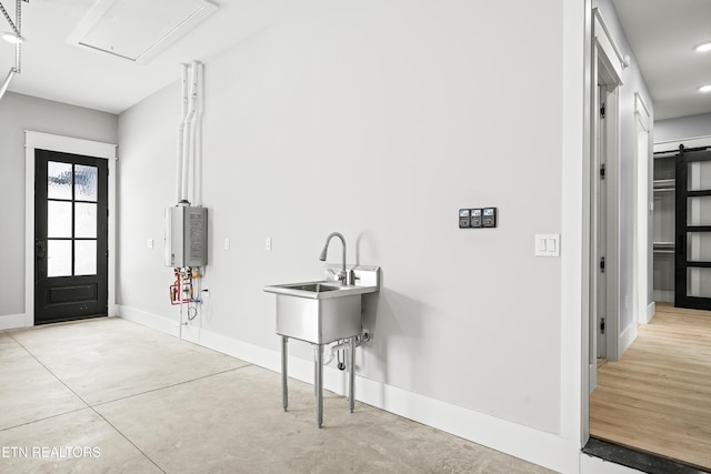 laundry area with a barn door and sink