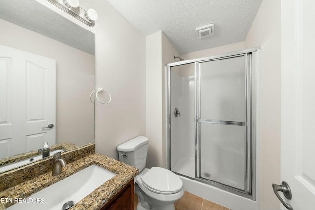 bathroom featuring tile patterned floors, an enclosed shower, vanity, a textured ceiling, and toilet