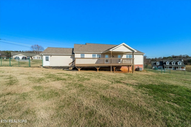 rear view of property featuring a deck, a yard, and central AC