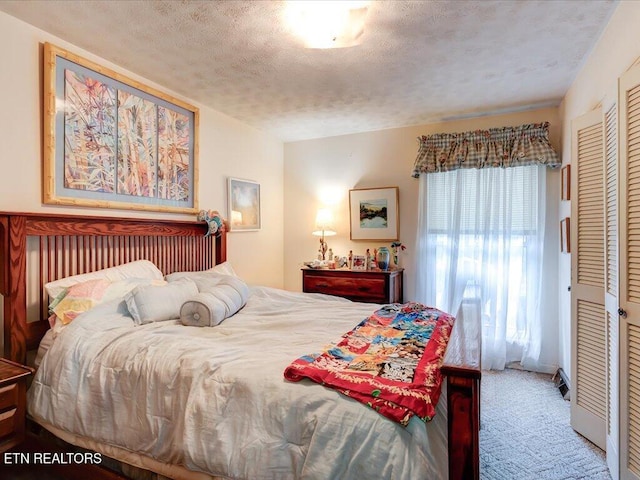 bedroom featuring carpet flooring, a textured ceiling, and a closet