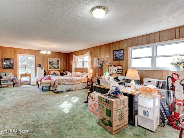 carpeted bedroom featuring a chandelier and a textured ceiling