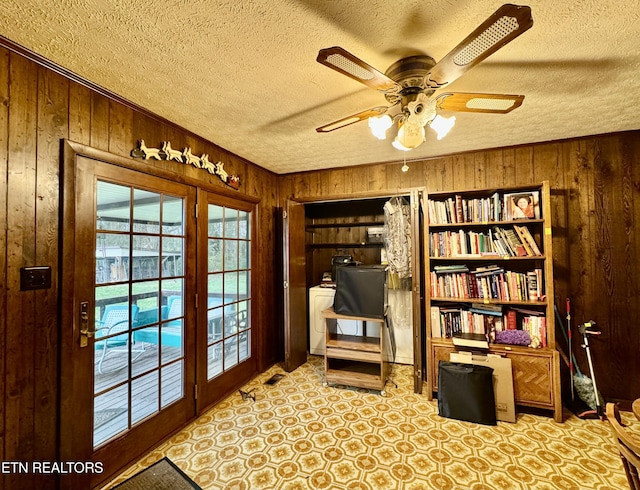 living area featuring a textured ceiling and wooden walls