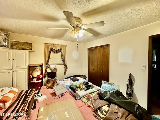 bedroom with ceiling fan, a textured ceiling, and a closet