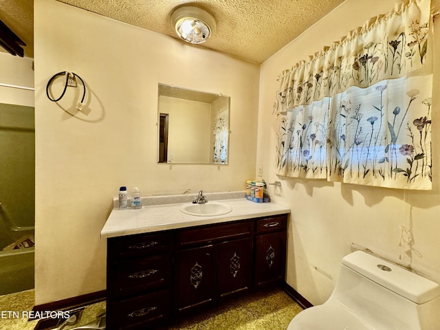 bathroom with vanity, toilet, and a textured ceiling