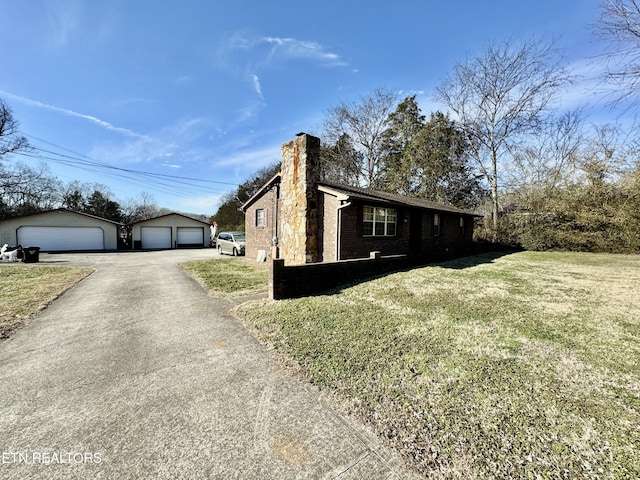 view of property exterior featuring a garage, an outbuilding, and a yard